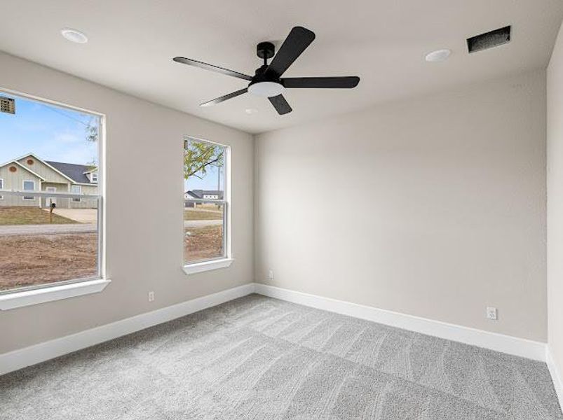 Spare room with carpet floors, plenty of natural light, and a ceiling fan Spare room with carpet floors, plenty of natural light, and a ceiling fan