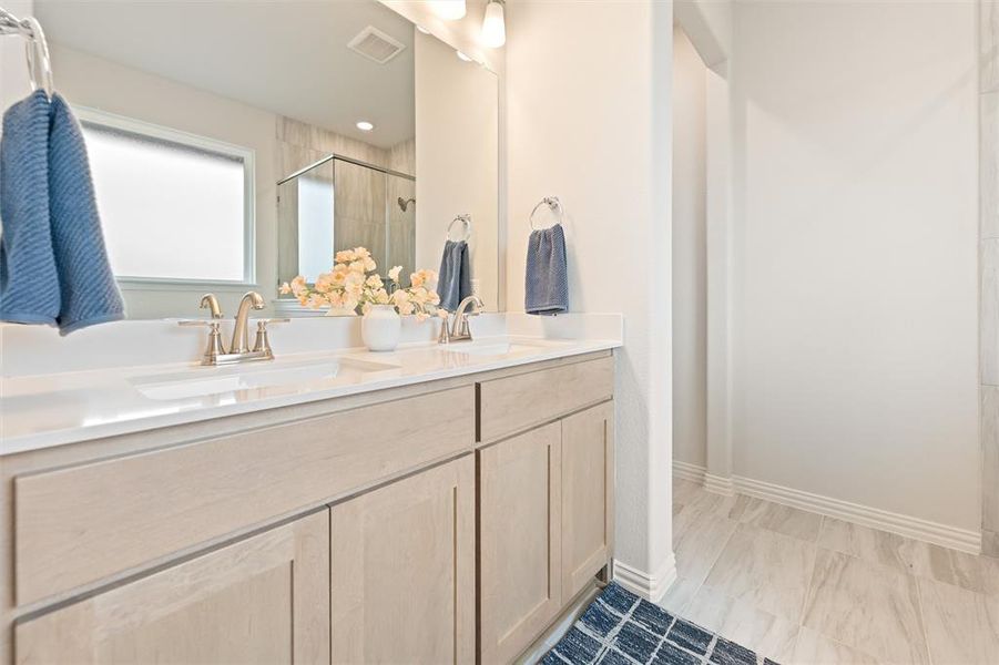 Bathroom featuring double vanity and a shower stall