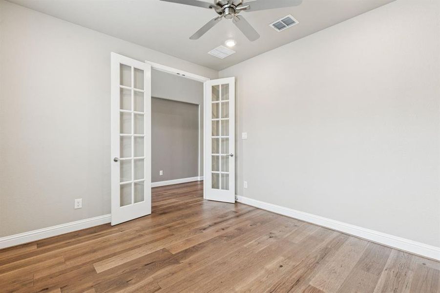 Unfurnished room featuring french doors, wood finished floors, and ceiling fan