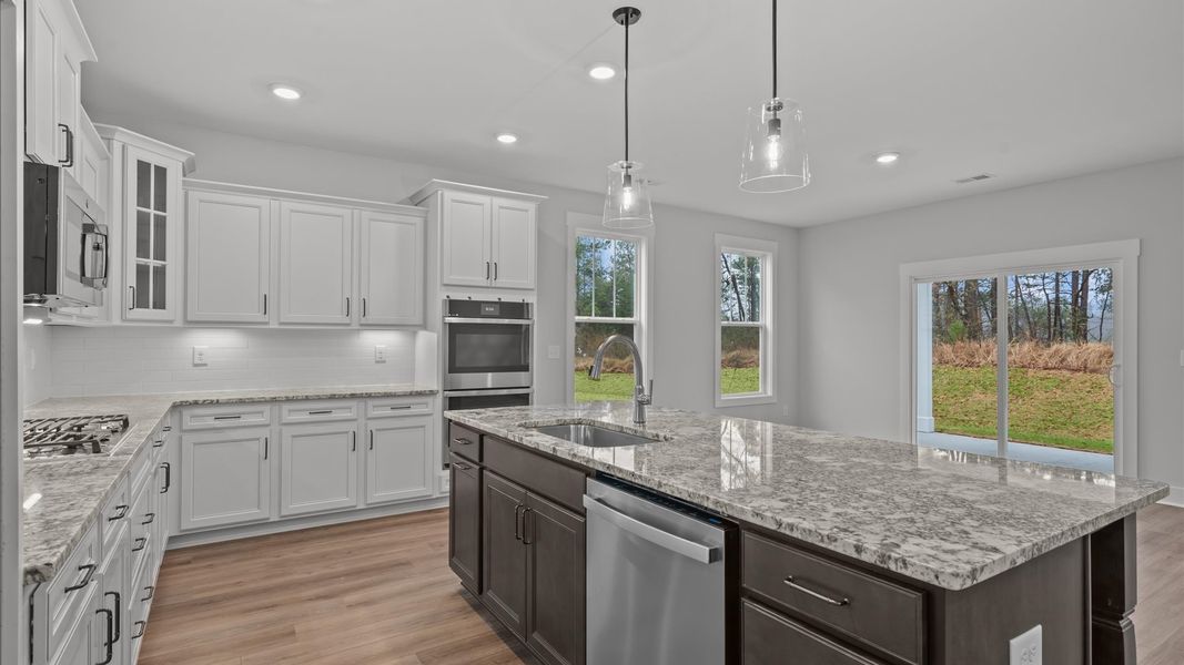 Tasteful design meets functional luxury in this kitchen with a 9-foot island and modern pendant lighting