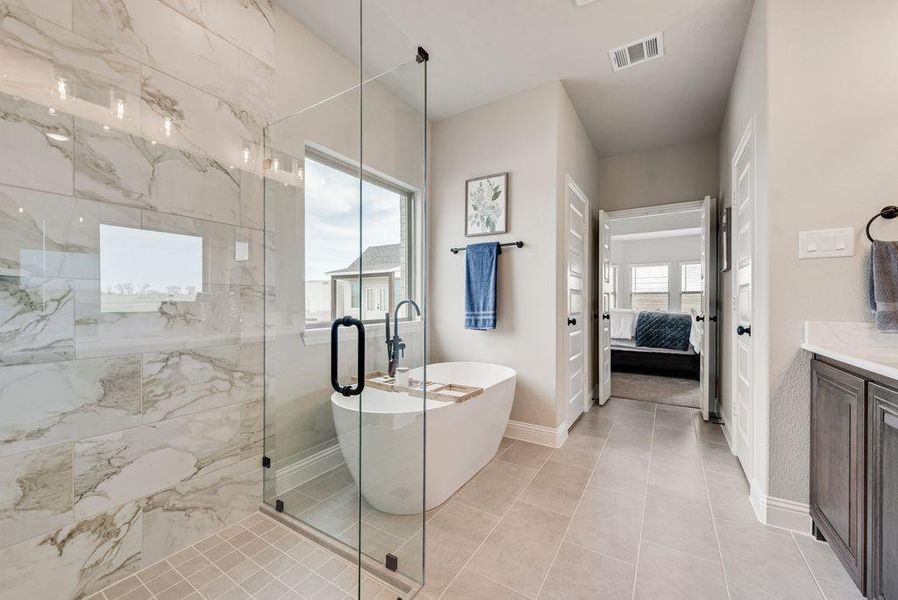 Dual granite vanity, 12x24 tile, full frameless glass shower, and freestanding tub make master bath feel like a spa. Photo of same exact plan with freestanding tub, but colors are different