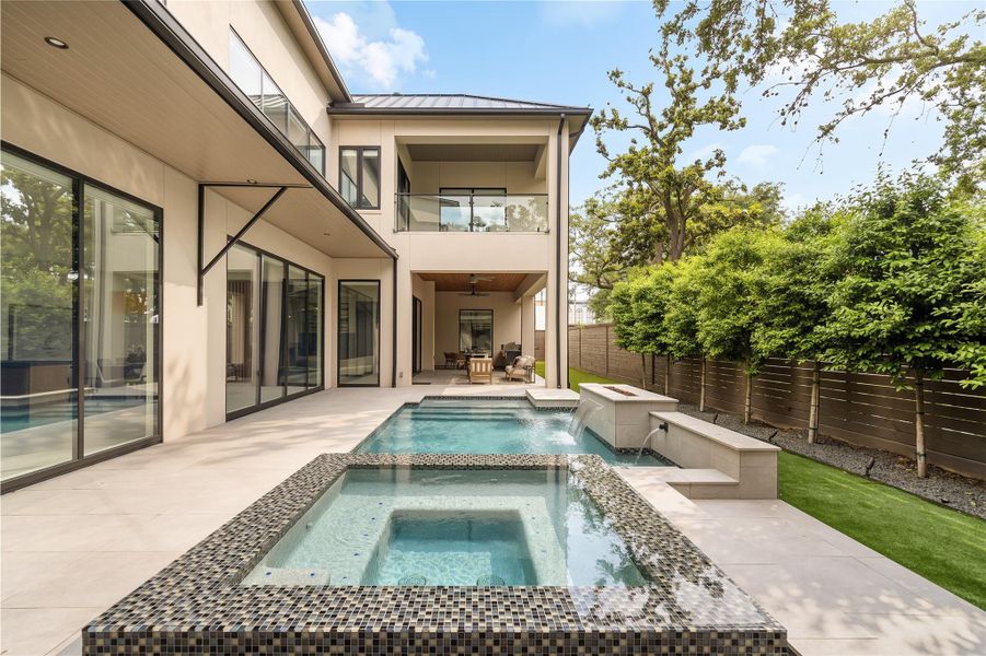Architecturally driven outdoor living with a covered patio, upper-level terrace, and a private pool courtyard below