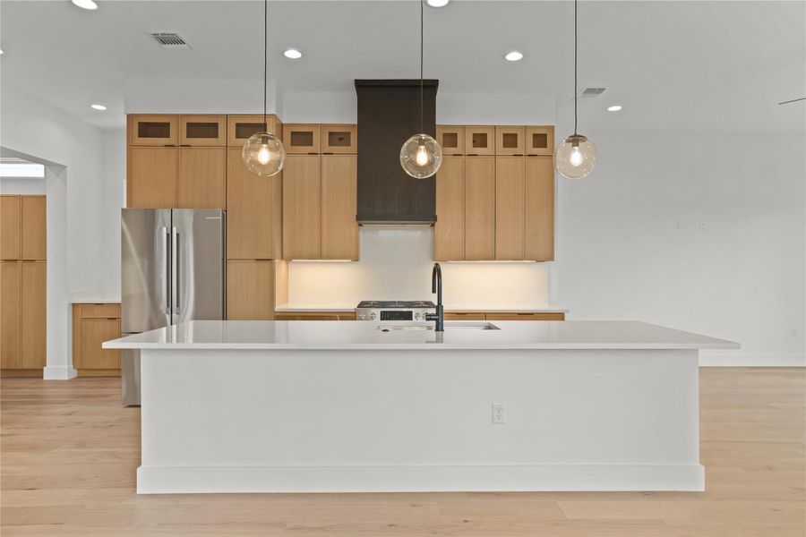 A well-lit kitchen with sleek wooden cabinetry and a spacious island.