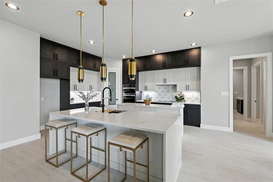 Kitchen with light wood finished floors, a spacious island, decorative backsplash, recessed lighting, and decorative light fixtures