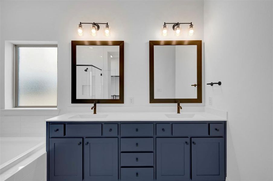 Full bathroom with double vanity, a garden tub, and a shower stall