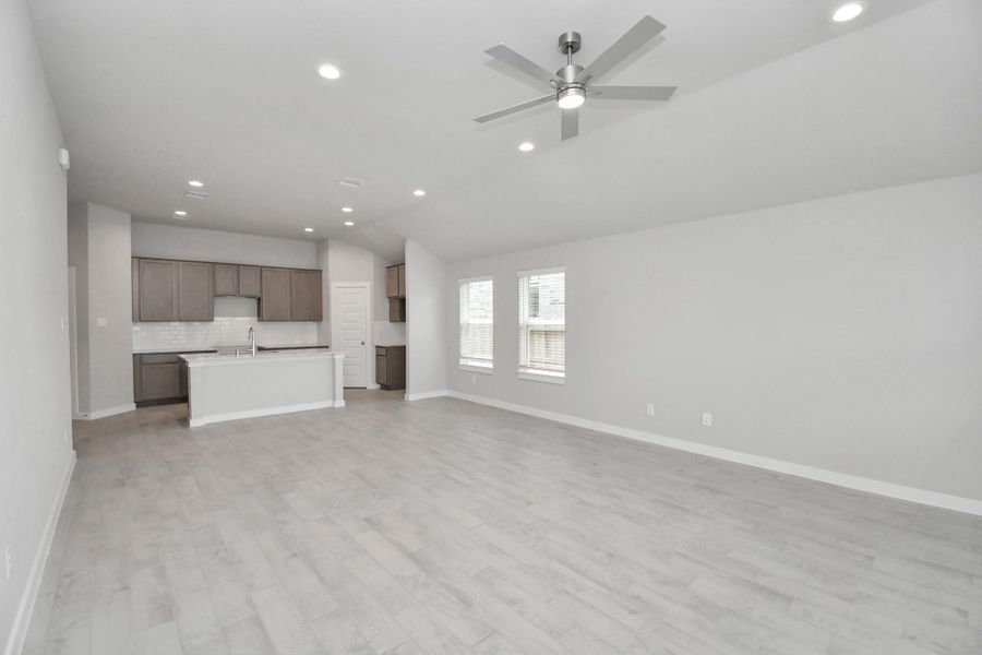 Bring your loved ones and guests together in the inviting living room! Boasting lofty high ceilings, recessed lighting, a stylish ceiling fan, custom paint, stunning flooring, and expansive windows that flood the space with ample natural light all day long.