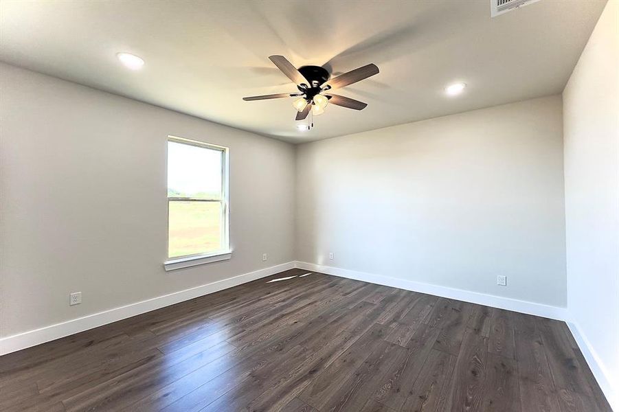Spare room with dark brown flooring, recessed lighting, and ceiling fan
