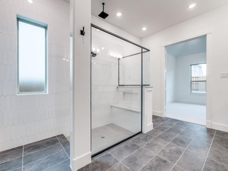 Featuring a spacious walk in shower with built in seat, you'll never want to leave this gorgeous owner's bath!