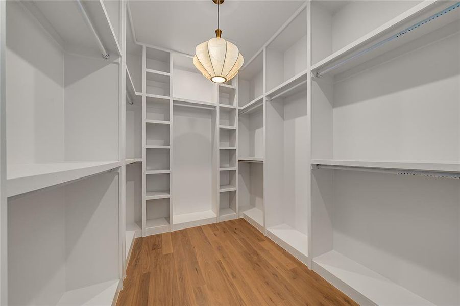 Walk in closet with light wood-style flooring Walk in closet with light wood-style flooring