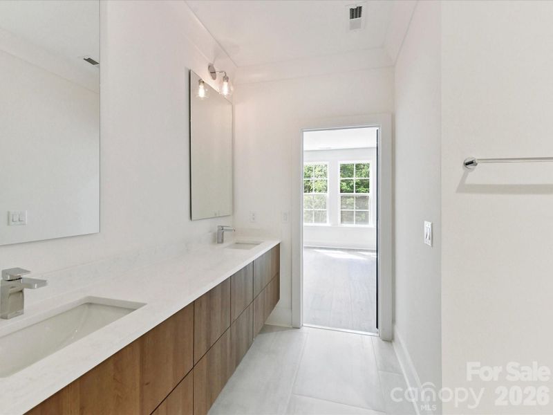 Jack-and-Jill bathroom with double vanity, modern finishes, and convenient access between adjoining bedrooms.