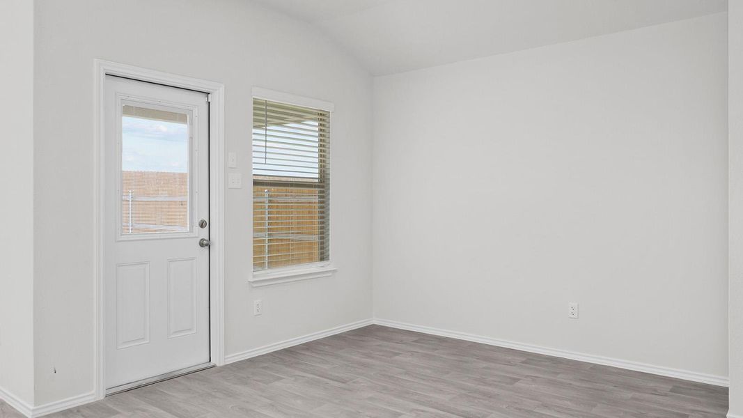 Spare room featuring lofted ceiling and light wood finished floors