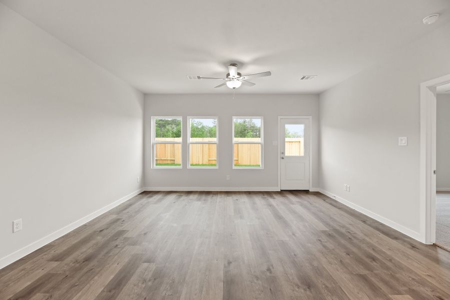 A room with a wood floor and a ceiling fan.