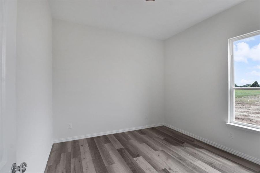 Empty room with plenty of natural light and hardwood / wood-style floors