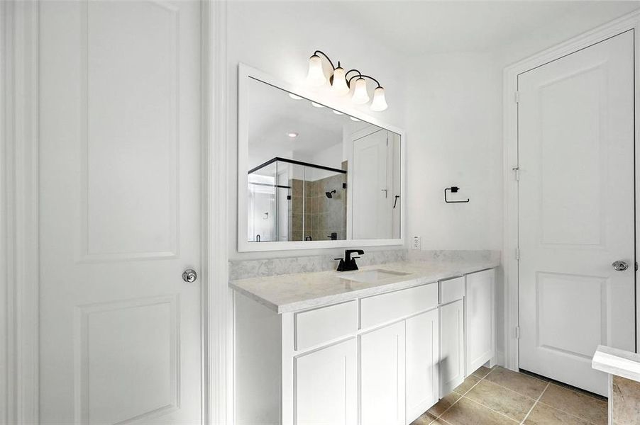 Bathroom with vanity, light tile patterned floors, a shower stall, and a closet