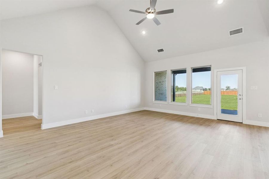 Unfurnished room featuring high vaulted ceiling, light wood-type flooring, recessed lighting, and ceiling fan
