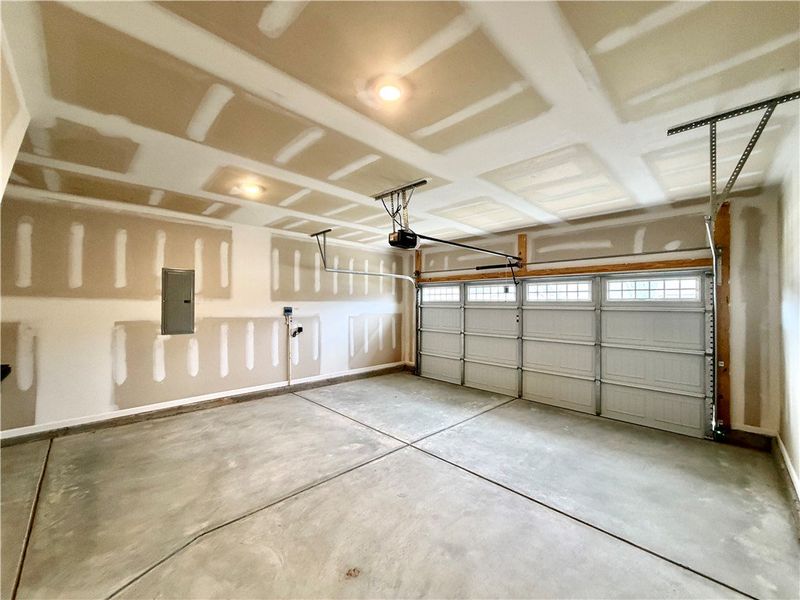 An unfinished double garage provides practical sto