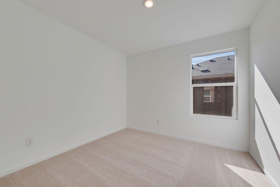 Empty room with light colored carpet and recessed lighting