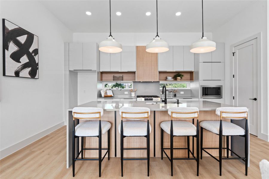 Intentional clerestory windows brighten the kitchen’s clean lines, with a walk-in pantry tucked just beyond the right-hand door. Intentional clerestory windows brighten the kitchen’s clean lines, with a walk-in pantry tucked just beyond the right-hand door.