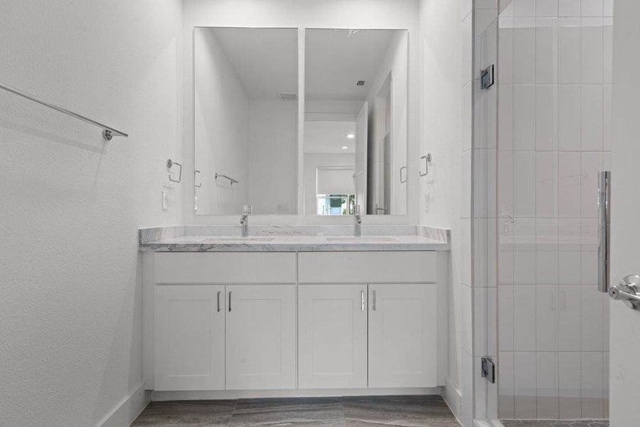 Crisp finishes and a double vanity define this modern bathroom space. Crisp finishes and a double vanity define this modern bathroom space.