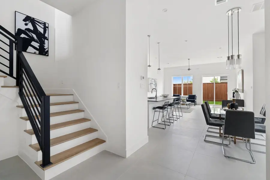 A sleek and modern staircase leads to the second floor, continuing the home's sophisticated design. A sleek and modern staircase leads to the second floor, continuing the home's sophisticated design.