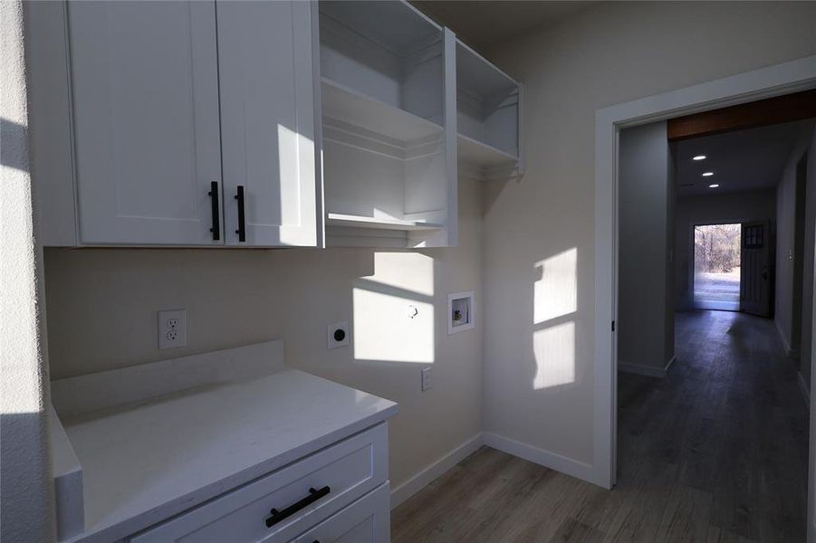 Laundry area with washer hookup, hookup for an electric dryer, light wood-style flooring, cabinet space, and recessed lighting