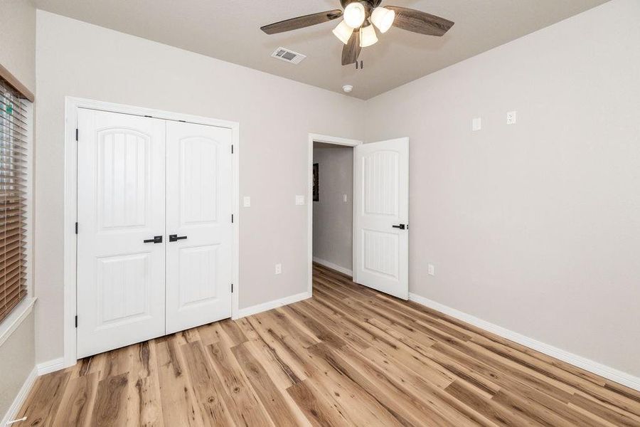 Unfurnished bedroom featuring ceiling fan, light hardwood / wood-style floors, and a closet