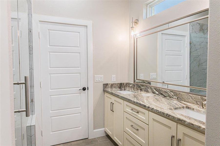 Bathroom featuring a marble finish shower and double vanity Bathroom featuring a marble finish shower and double vanity