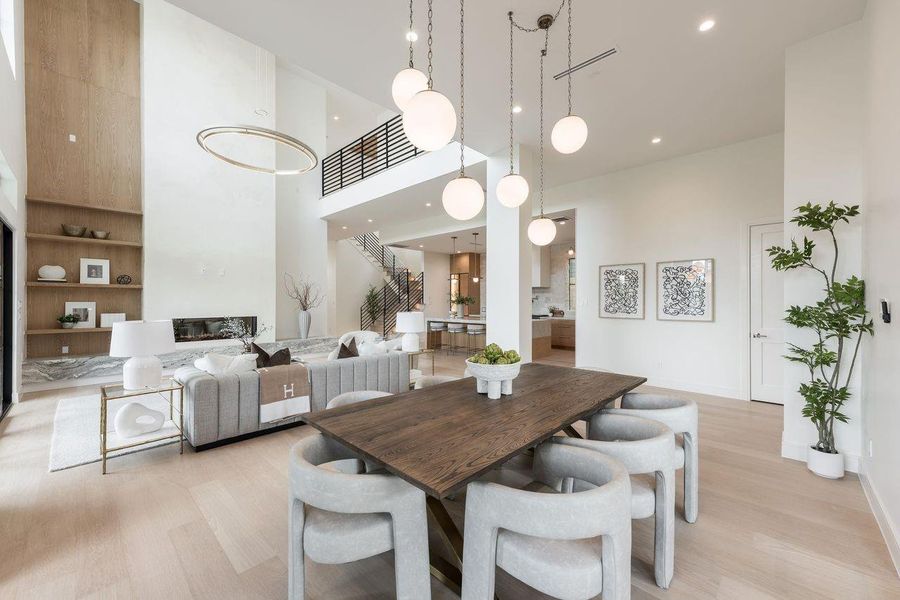 Designed to impress from every vantage point, this stunning central living space blends vertical volume with warm natural finishes. The linear fireplace glows beneath a dramatic ceiling height, while the open stair and upper gallery add visual interest, creating a home that feels elevated, connected, and effortlessly sophisticated.