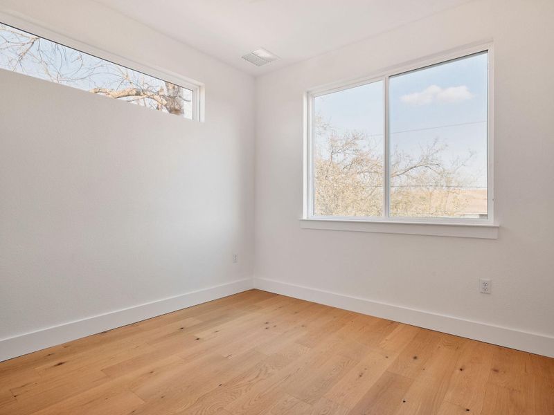 Spare room with baseboards and light wood-type flooring