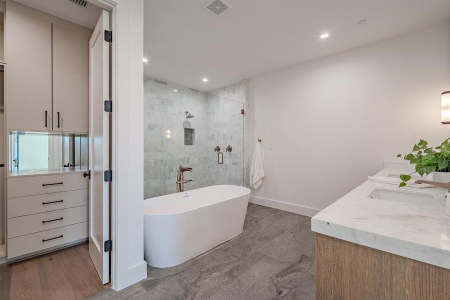 Bathroom featuring a shower stall, a freestanding bath, double vanity, and recessed lighting Bathroom featuring a shower stall, a freestanding bath, double vanity, and recessed lighting