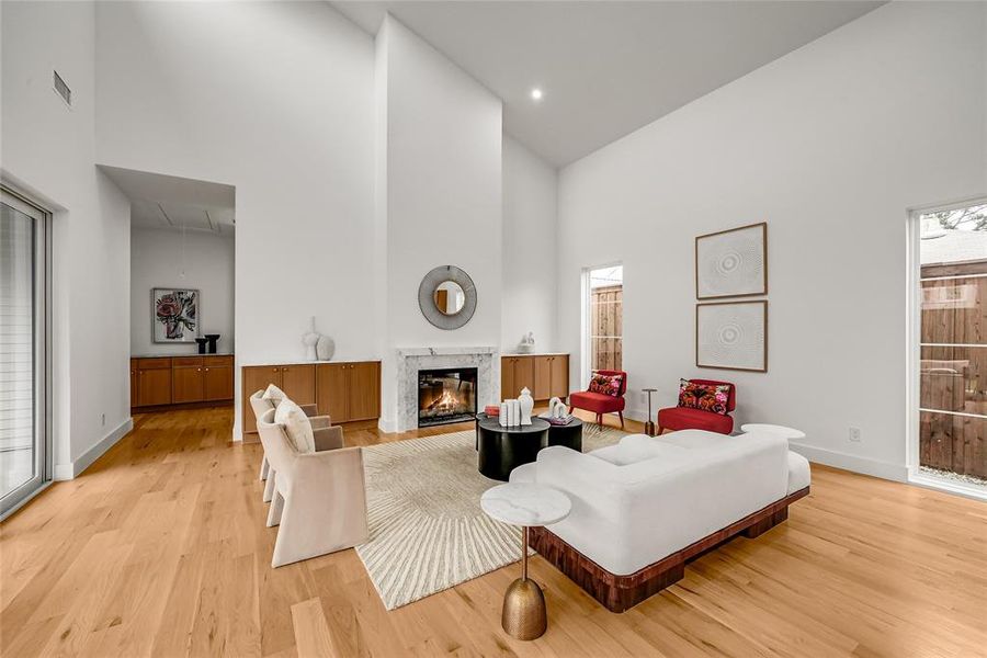 Spacious living area featuring soaring vaulted ceilings and light wood-finish flooring