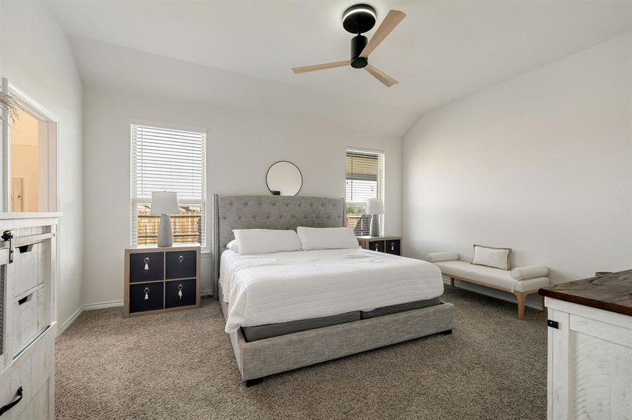 Carpeted bedroom featuring lofted ceiling and ceiling fan Carpeted bedroom featuring lofted ceiling and ceiling fan