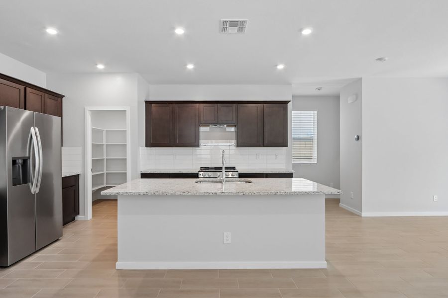 A kitchen with a marble counter top.