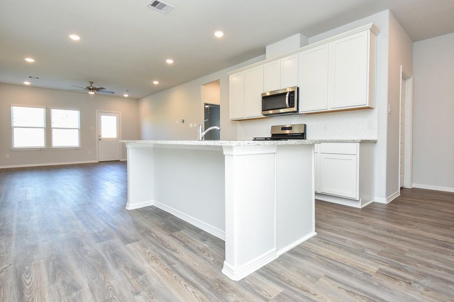 Creamy 42-inch cabinetry fills this generous, workable kitchen. Note the great extended granite island countertop, just waiting for some comfy stools! Creamy 42-inch cabinetry fills this generous, workable kitchen. Note the great extended granite island countertop, just waiting for some comfy stools!