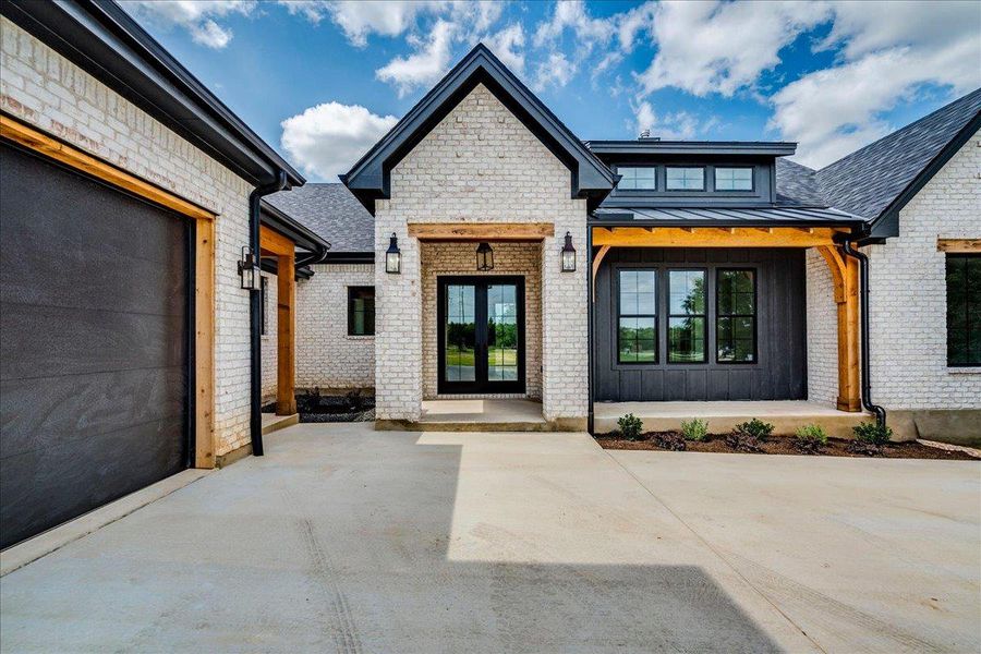 A striking modern farmhouse facade with light brick and dark trim offers exceptional curb appeal.
