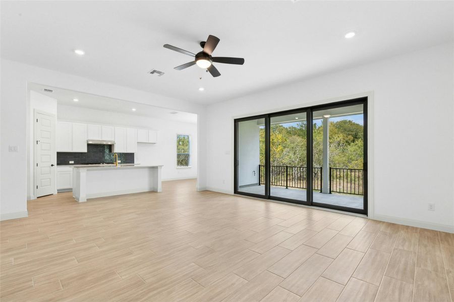 Unfurnished living room featuring recessed lighting, wood tiled floors, plenty of natural light, and ceiling fan Unfurnished living room featuring recessed lighting, wood tiled floors, plenty of natural light, and ceiling fan