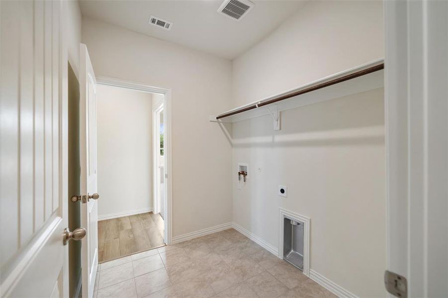 Laundry room featuring electric dryer hookup, washer hookup, and light tile patterned floors