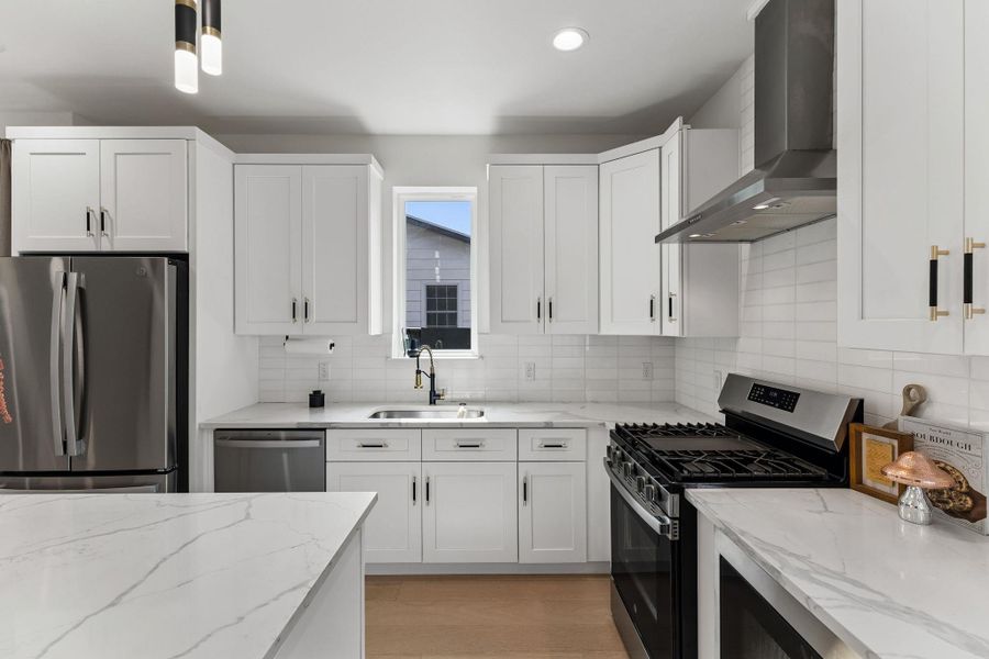 A direct view of the kitchen sink area, featuring a gold-and-black gooseneck faucet. The window above the sink provides a view of the exterior, ensuring the workspace remains bright and connected to the outdoors.