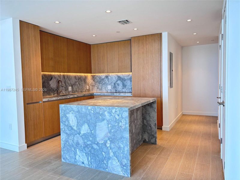 Kitchen with custom island in matching ItalKraft cabinetry and quartzite waterfall Kitchen with custom island in matching ItalKraft cabinetry and quartzite waterfall