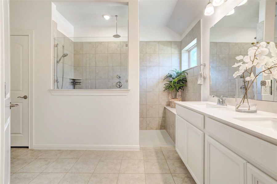 Full bath featuring walk in shower, double vanity, and tile patterned flooring