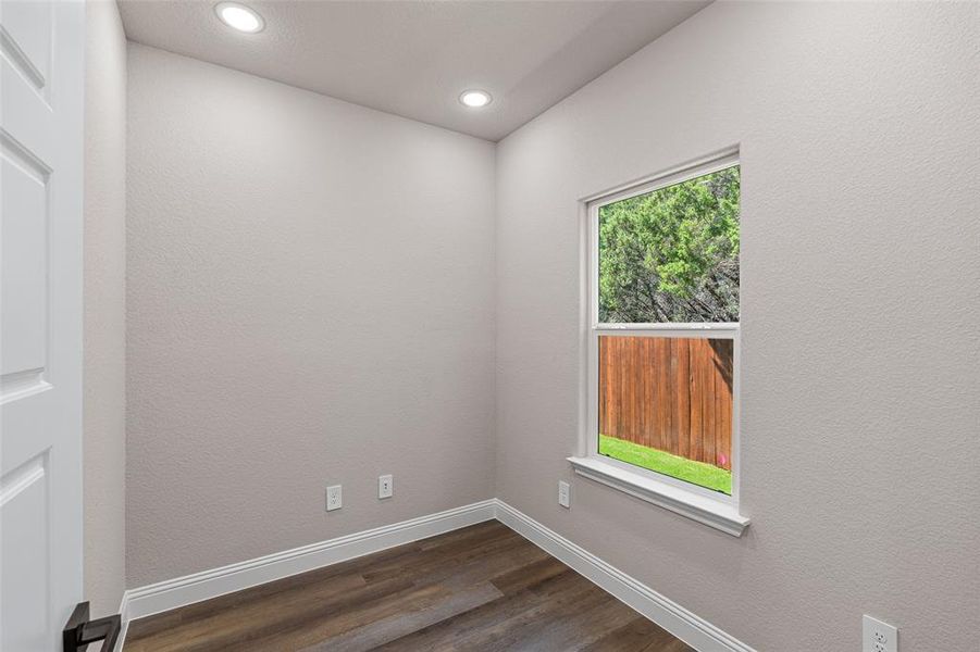 Unfurnished room featuring plenty of natural light and dark hardwood / wood-style flooring