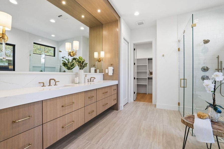 Bathroom with a spacious closet, double vanity, a shower stall, recessed lighting, and light wood-style flooring