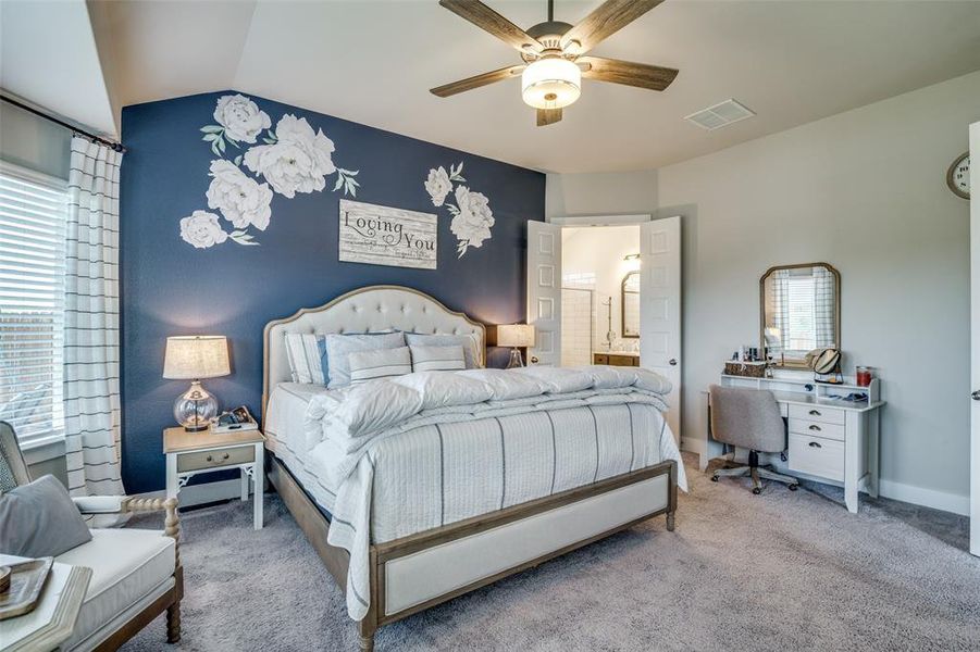 Carpeted bedroom featuring connected bathroom, lofted ceiling, and ceiling fan