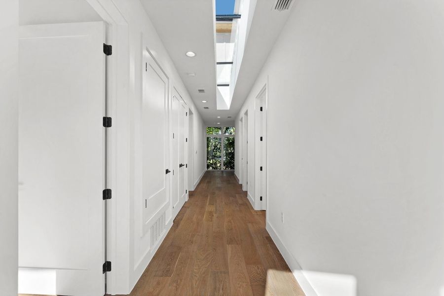 Hall featuring dark wood-style flooring, recessed lighting, and a skylight Hall featuring dark wood-style flooring, recessed lighting, and a skylight