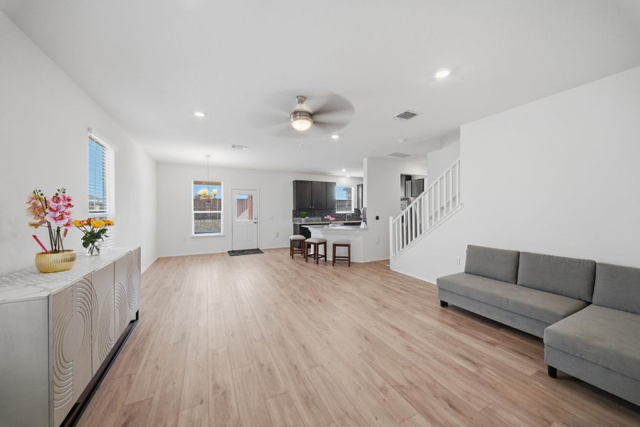 A spacious, naturally illuminated living area flows seamlessly into a modern kitchen, featuring sleek wooden floors and a contemporary aesthetic. A spacious, naturally illuminated living area flows seamlessly into a modern kitchen, featuring sleek wooden floors and a contemporary aesthetic.