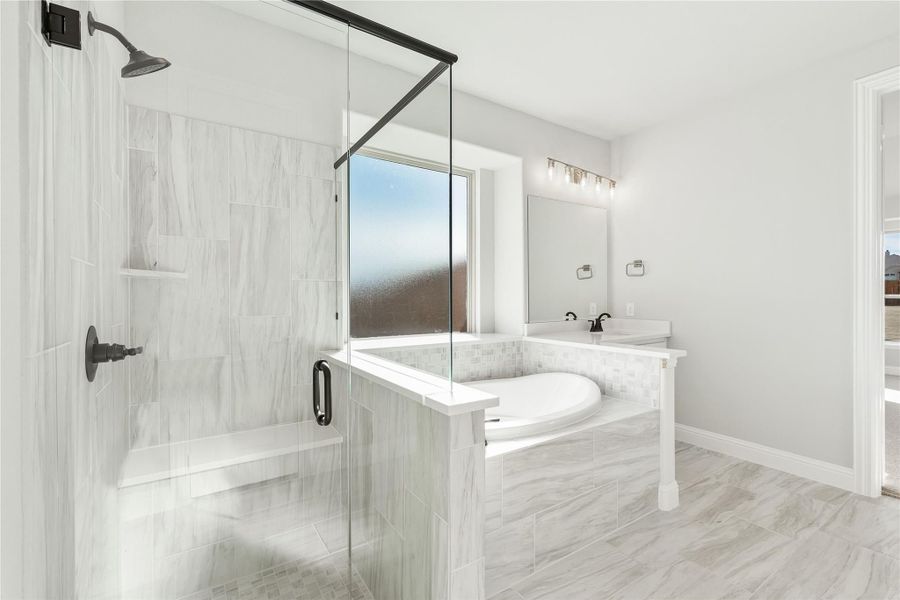 Master bathroom with glass walk-in shower, soaking tub, and double vanity on light tile floors Master bathroom with glass walk-in shower, soaking tub, and double vanity on light tile floors