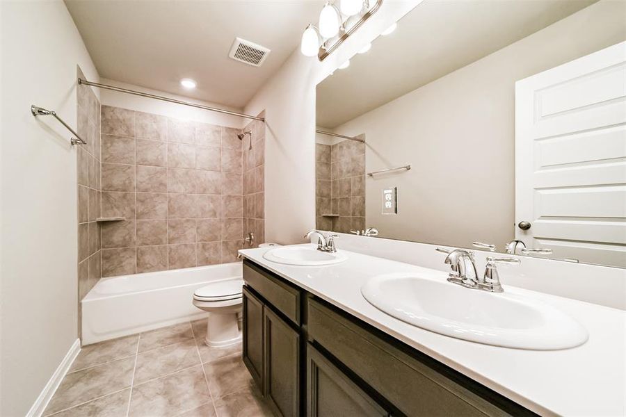 Upstairs bathroom to share between guests or roomies, complete with a shower & tub combo & jack & jill sinks