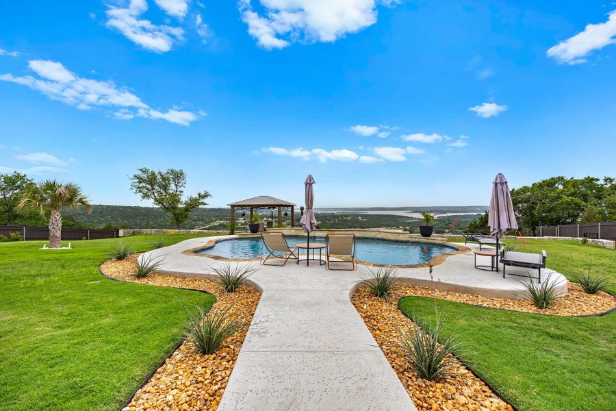 An inviting backyard oasis features a freeform pool, a charming gazebo, and expansive views of the distant lake. An inviting backyard oasis features a freeform pool, a charming gazebo, and expansive views of the distant lake.