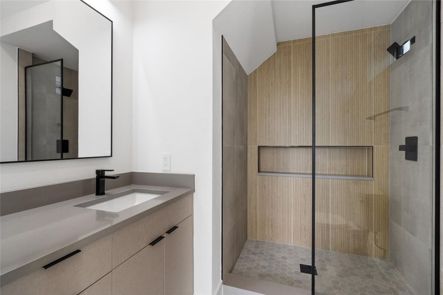 Warm wood detailing softens this contemporary bath, creating a seamless dialogue between precision and comfort. Thoughtful finishes elevate the space beyond function into something intentional and serene.