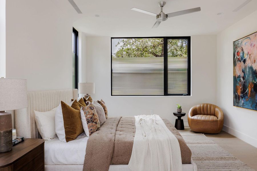 Bedroom featuring wood finished floors, multiple windows, and ceiling fan Bedroom featuring wood finished floors, multiple windows, and ceiling fan